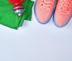 roze sport- sportschoenen en groen kleren Aan een wit achtergrond foto