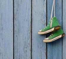 groen textiel schoenen hangen Aan een blauw achtergrond foto