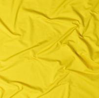 fragment van geel verfrommeld katoen kleding stof foto