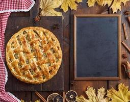 leeg zwart krijt bord en gebakken geheel fruit taart foto