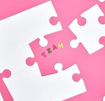 wit groot puzzels Aan een roze achtergrond, opschrift team foto
