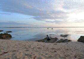 mannen Aan de strand en zonsondergangen Aan de strand. paradijs strand. tropisch paradijs, wit zand, stranden en Doorzichtig water. een landschap met zonsondergangen Aan de zee kust. foto