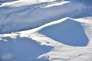 besneeuwd oppervlak. wit sneeuw en sneeuwbanken in winter. foto