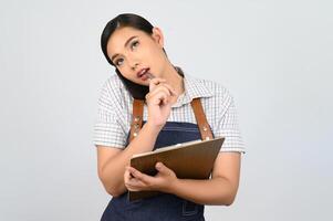 portret van jong Aziatisch vrouw in serveerster uniform houding met smartphone foto