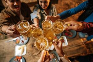 portret van gelukkig Aziatisch vrienden hebben avondeten partij samen - jong mensen roosteren bier bril avondeten buitenshuis - mensen, voedsel, drinken levensstijl, nieuw jaar viering concept. foto