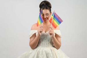 jong Aziatisch mooi bruid met regenboog vlag Aan wit achtergrond foto