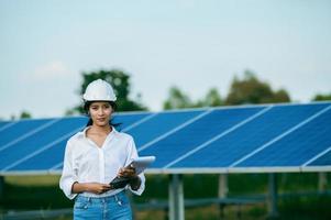 Aziatisch jong ingenieur vrouw controle operatie in zonne- boerderij foto