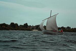 zeilboot drijvend Aan water somber landschap foto