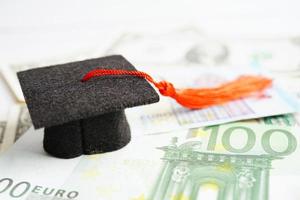 afstuderen gap hoed op euro en Amerikaanse dollar bankbiljetten geld, onderwijs studie vergoeding leren leren concept. foto