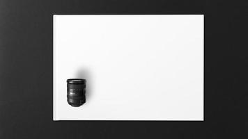 cameralens op wit papier op zwarte achtergrond foto