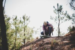 wandelaar met kaart en grote reizende rugzak die naar de berg reist foto