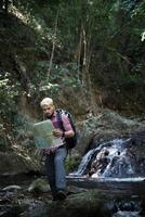 avontuurlijke man observeren kaart op een bergpad