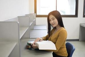 jonge Aziatische studentenlezing in de bibliotheek foto