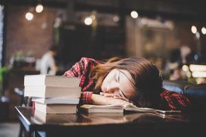 portret van een hipster tiener slapen op tafel in café foto