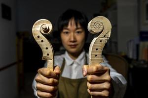 jong Chinese viool maker Bij werk in haar werkplaats foto