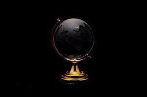 zwart wereldbol Aan zwart achtergrond foto