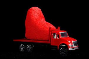 rood hart Aan een speelgoed- vrachtauto foto