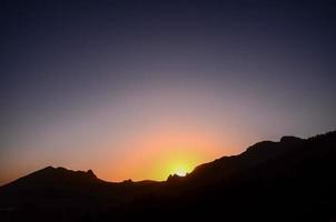 zonsondergang over- de heuvels foto