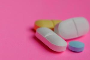 kleurrijk drugs. pillen en capsules Aan een roze achtergrond. kopiëren ruimte. foto