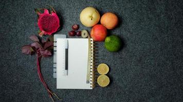gezond fruit en groenten met boek Aan donker achtergrond. eetpatroon gezond voedsel concept foto