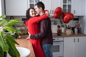 Mens en vrouw in liefde datum Bij huis in keuken gelukkig knuffels. Valentijnsdag dag, gelukkig stel, liefde verhaal. liefde nest, behuizing voor jong familie foto