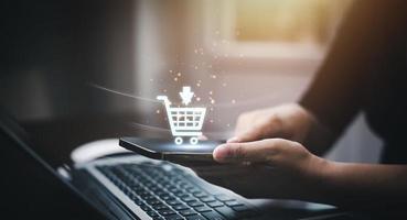 zakenman gebruik makend van een laptop met online boodschappen doen concept, marktplaats website met virtueel koppel van online boodschappen doen kar een deel van de netwerk, online boodschappen doen bedrijf met selecteren boodschappen doen kar. foto