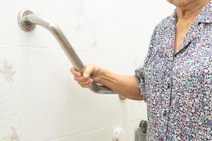 Aziatische senior of oudere oude dame vrouw patiënt gebruik toilet badkamer handvat beveiliging in verpleegafdeling ziekenhuis, gezond sterk medisch concept. foto