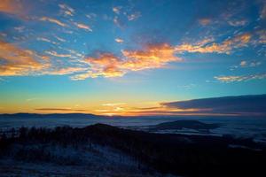 zonsondergang over- bergen gedekt met Woud foto