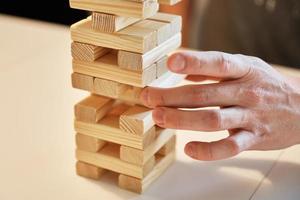 familie Speel bord spel. handen nemen houten blok van toren. foto