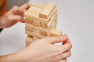 familie Speel bord spel. handen nemen houten blok van toren. foto