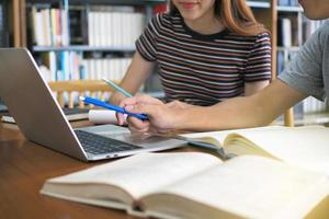 hoog school- studenten of studenten zijn lezing en aan het studeren. gebruik computers en boeken net zo een bron van kennis. binnen de bibliotheek foto