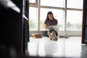 Aziatisch meisjes zijn op zoek Bij informatie Aan laptops. met een glimlach van viewing informatie en aan het leren foto