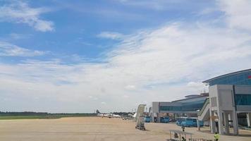 visie van vliegtuig in de parkeren veel van de luchthaven met aerobrug faciliteit. Doorzichtig blauw lucht. foto