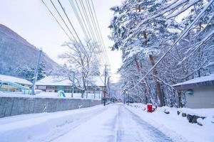 Nikko, Japan - 26 januari 2023. wolfraam lamp en een Japans dorp teken, zwaar sneeuw gedekt weg Bij hoi Nee sato dorp in tochigi prefectuur, nikko stad, foto