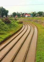 de rivier- stromen naar de dam voor rijst- veld- irrigatie foto