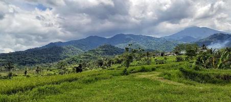 mooi berg landschap met wolken klonteren bovenstaand het. landelijk dorp in een berg vallei in Indonesië. berg visie. tropisch Woud. natuur achtergrond. foto