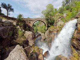 Ponte da misarela of brug van mizarela in montalegre, Portugal met een groot waterval De volgende naar het gedurende een zonnig dag. landelijk reizen en vakantie in natuur. foto