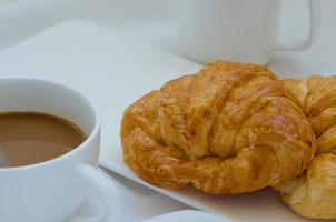 boter croissant en een kop van koffie voor ontbijt foto