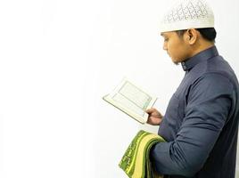 man die de koran vasthoudt en leest. islamitische achtergrond foto