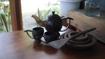 theepot en theekopje Aan een houten tafel in de tuin foto