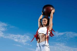achtergrond lucht. atletisch vrouw met med bal. sterkte en motivatie.foto van sportief vrouw in modieus sportkleding foto