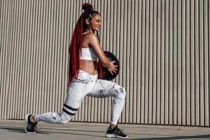 atletisch vrouw aan het doen uithaal opdrachten met med bal. sterkte en motivatie.foto van sportief vrouw in modieus sportkleding foto