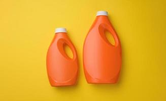 oranje plastic fles voor vloeistof het wassen poeder Aan geel achtergrond foto