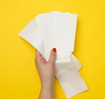 vrouw hand- houdt een stack van papier cheques Aan een geel achtergrond. account analyse, belastingen foto