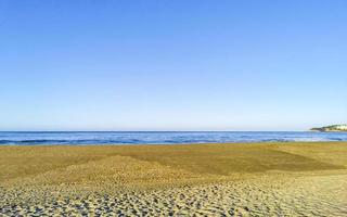 zon strand zand mensen golven palmen in puerto escondido Mexico. foto