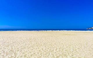 zon strand zand mensen golven palmen in puerto escondido Mexico. foto