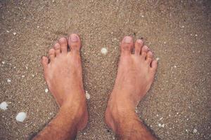jonge man voeten op het strand foto