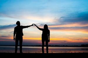 silhouet van een jong koppel tijdens zonsondergang foto