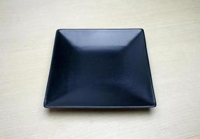 vierkante zwarte plaat op tafel foto