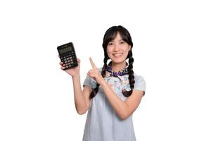 portret van mooi jong Aziatisch vrouw in denim jurk Holding rekenmachine Aan wit achtergrond. bedrijf boodschappen doen online concept. foto